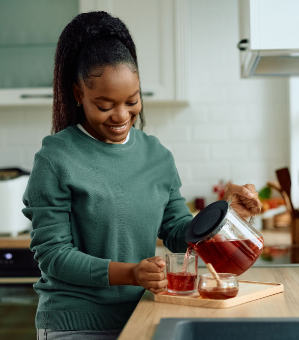 young happy black woman making tea in the kitchen 1000px
